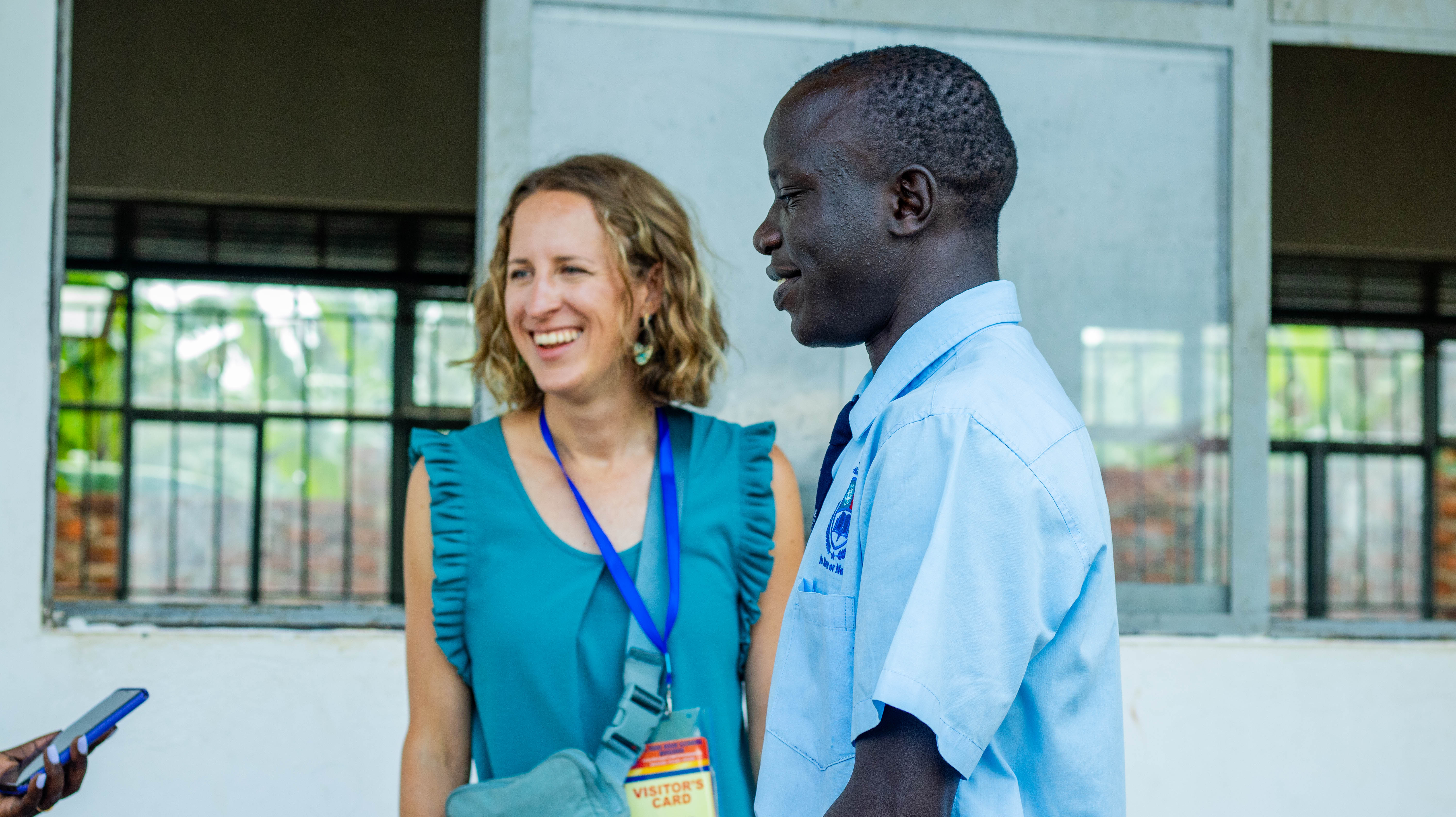 A student in a blue uniform speaking with a visitor