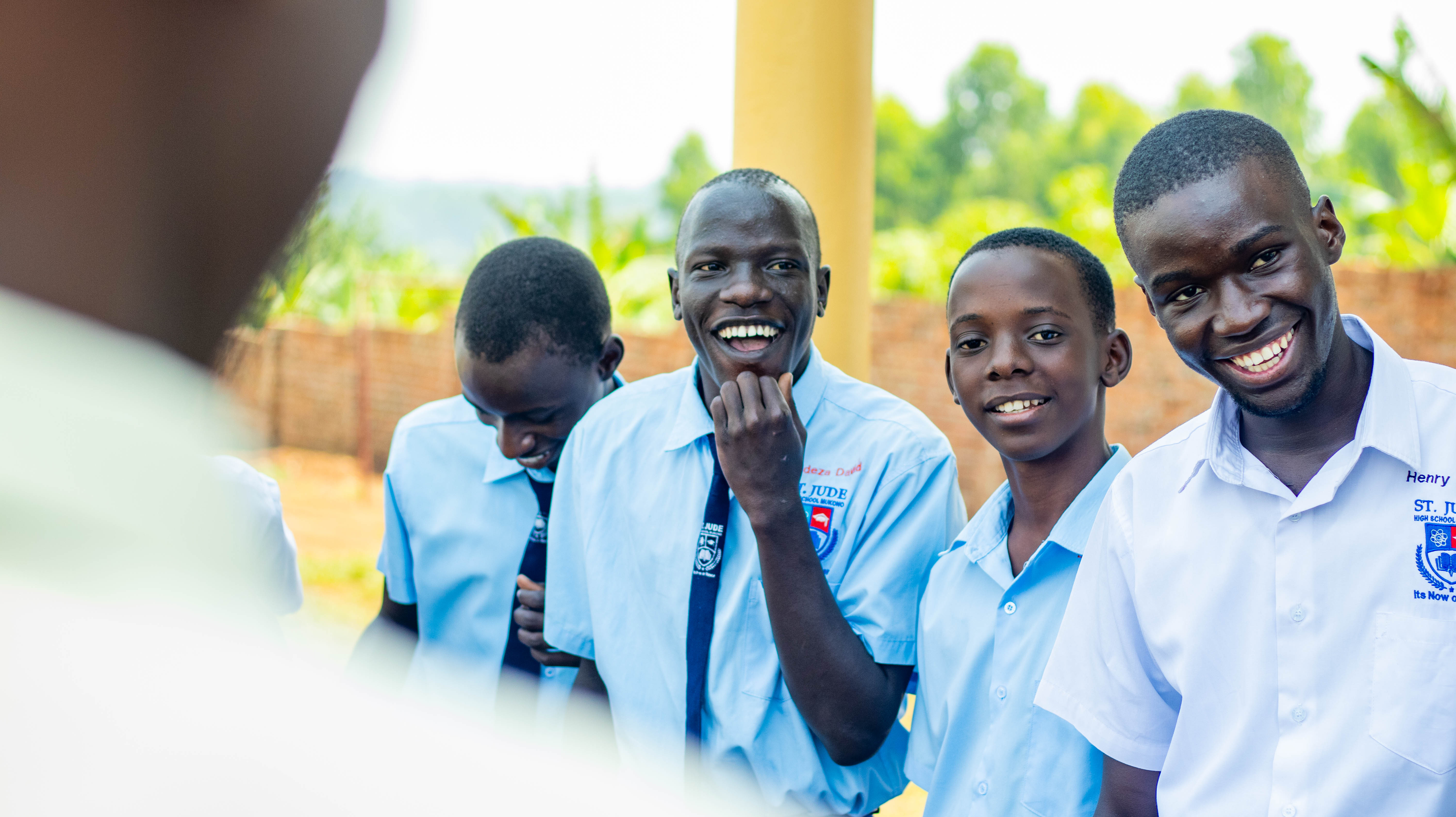 Students in school uniforms smiling together outdoors